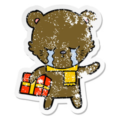 distressed sticker of a crying cartoon bear with present