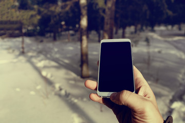 men using smartphone in winter forest