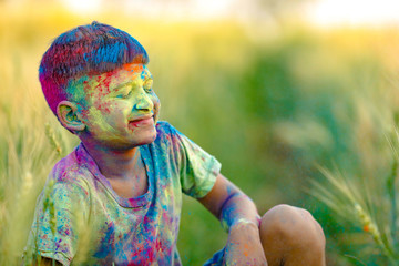Indian child playing with the color in holi festival