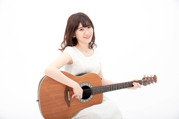 笑顔でアコーステックギターを弾く女性