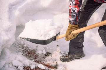 Clean the snow with a shovel. The man shovels snow shovels. Snow shovel in hand. Cleaning the area...