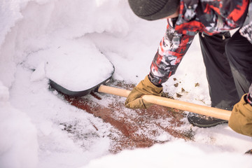 Clean the snow with a shovel. The man shovels snow shovels. Snow shovel in hand. Cleaning the area...