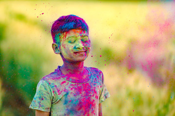 Indian child playing with the color in holi festival