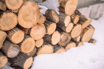 Firewood under the snow. Firewood in winter. Waste from the tree. Sawwood tree. Woodpile Logs lie under the snow.