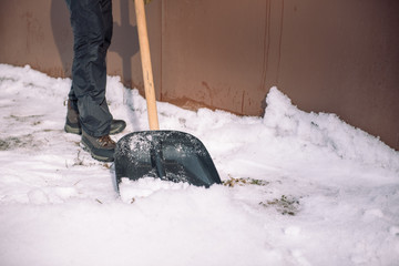 Clean the snow with a shovel. The man shovels snow shovels. Snow shovel in hand. Cleaning the area...