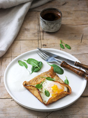 Breton buckwheat crepes with egg, spinach and cream, filed with the coffee. Rustic style.