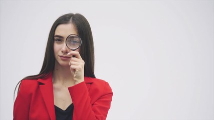 Funny expressions. Shocked woman looking at magnifying glass. A surprised girl looks at opening the keys with big eyes through a magnifying glass, isolated on a white background. - Powered by Adobe