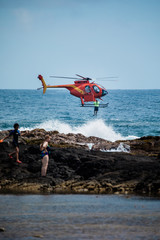 Helicopter dropping rescue diver off Hawaiian beach. © Jordan