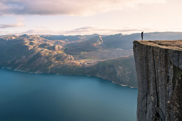 panoramic view of a girl hiking in Norway in winter at the top of the pulpit in the Preikstolen