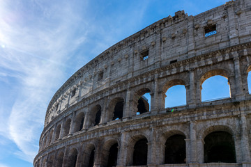 Obraz premium Facade of the Great Roman Colosseum (Coliseum, Colosseo), also known as the Flavian Amphitheatre. Famous world landmark. Scenic urban landscape.