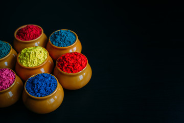Colorful Holi powder in cups closeup. Bright colours for Indian holi festival in clay pots....