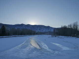cold winter sunrise scene along a frozen river