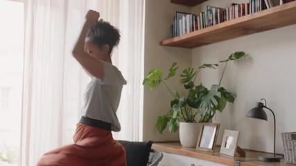 happy young woman dancing at home having fun celebrating summer vacation enjoying playful dance to celebrate successful lifestyle 