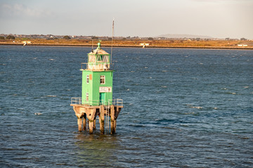 Green buoy tower lighthouse at Dublin harbour