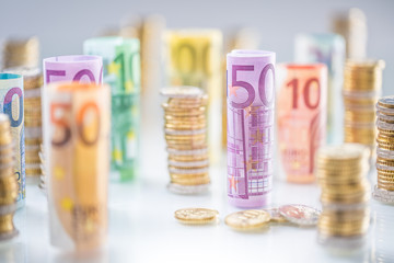 Rolled euro banknotes and coins towers stacked in other positions
