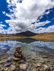 Reflections in the Dhankar lake with clouds floating across the Spiti valley
