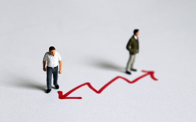 Miniature men standing in front of the arrow. The concept of intergenerational conflict.