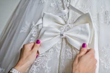 Obraz na płótnie Canvas Mom tying the bride's wedding dress, the hotel's interior