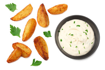 Fried potato wedges with garlic sauce in black bowl isolated on white background. top view.
