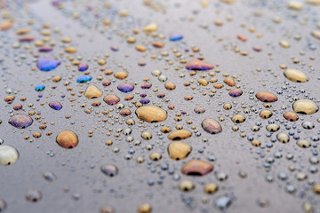 large orange-colored water spots on the dark surface, oil got into the water