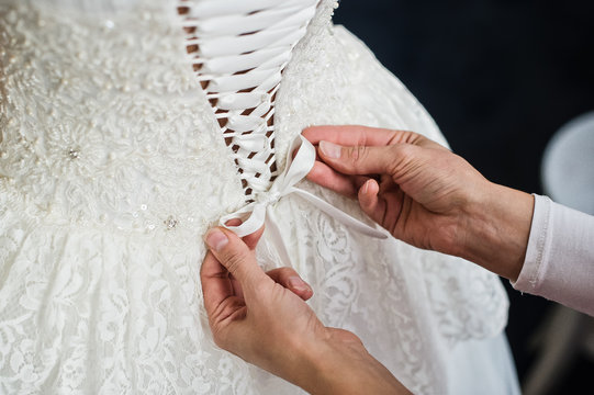 Back View Of The Wedding Dress, Mother's Hands Tie The Bride's Dress