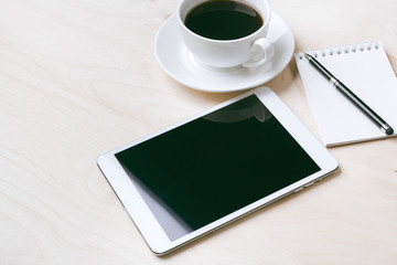 Fototapeta na wymiar Digital tablet computer and cup of coffee on wooden desk.