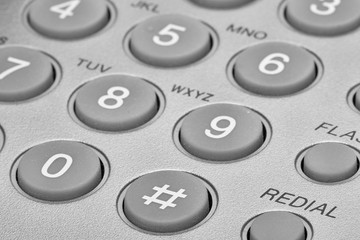 A close up of a Black office IP Phone on a desk