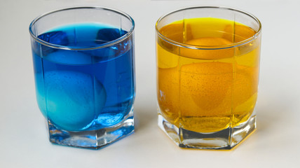 Painting eggs in yellow and blue for Easter