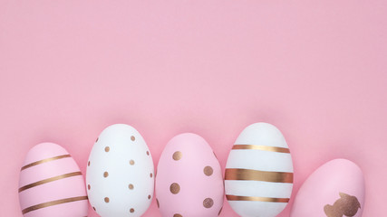 Many easter eggs on trendy pink pastel background. Eggs are hand-drawn. Flat lay style. Copyspace for text. Minimalism concept. Happy Easter.