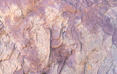 Stone texture background with unique pattern. Brown and prople rock texture. Rock surface abstract background. Natural stone background. Purple rough stone floor. Grunge and rust rock texture.