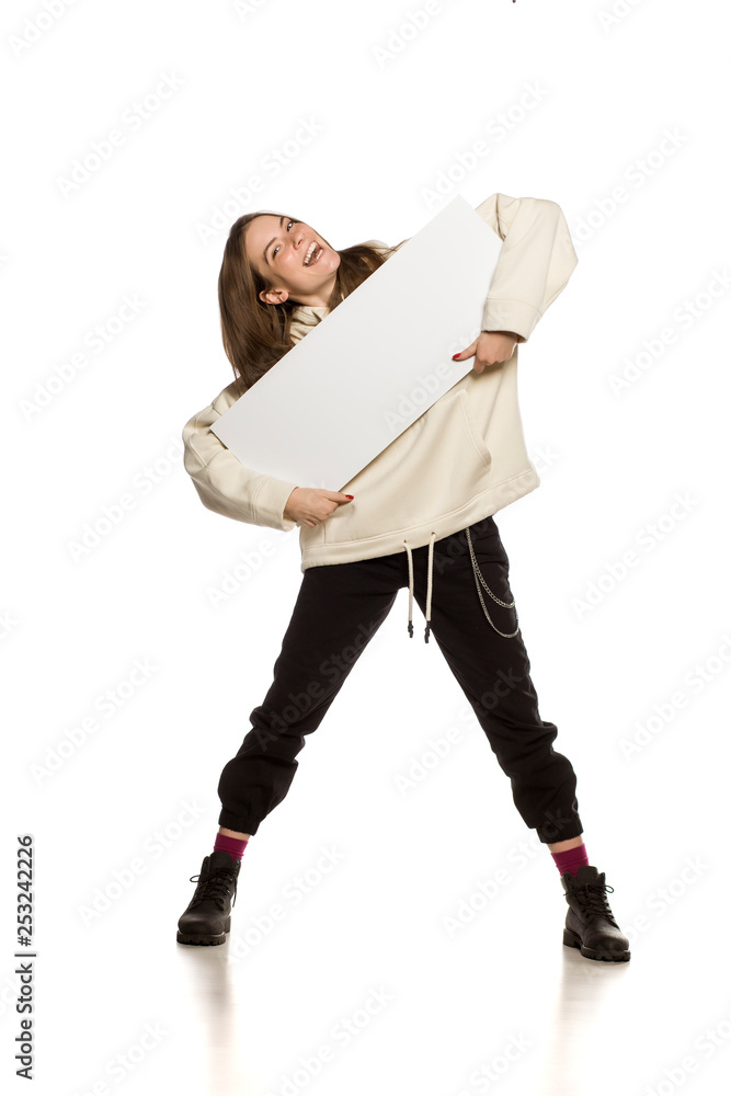 Poster Young model in hoodie holding an empty advertising board on white background