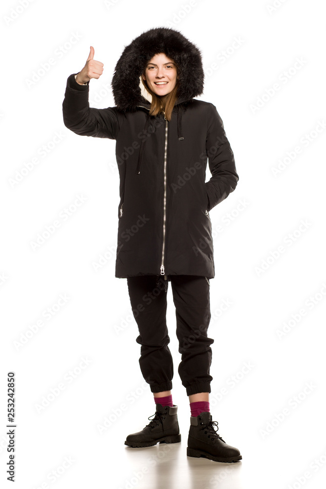 Poster Young model in winter jacket with hood posing on white background