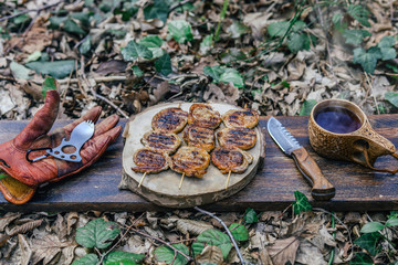 campfire red meat in pan, near the fire outdoors. bushcraft, adventure, tea, knife and camping concept.