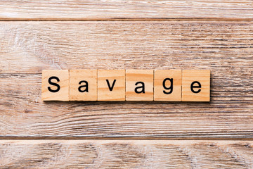 SAVAGE word written on wood block. SAVAGE text on wooden table for your desing, concept