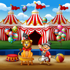Circus trainer performs a trick along with a lion at the arena