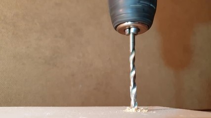 The Drilling a hole in a tree in slow motion close-up. Drilling with a metal drill. - Powered by Adobe