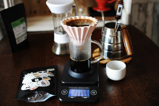 Alternative manual hand coffee brewing in pink ceramic origami dripper with paper filter. Grinder. Gooseneck kettle. Electronic scale
