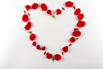 Heart shape made of red rose petals, on white background. Top view, copy space for text