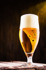 Cold beer into a glass with  foam.