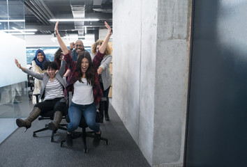 Fototapeta na wymiar multiethnics business team racing on office chairs