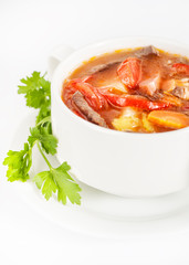 Bowl with delicious soup with meat on white
