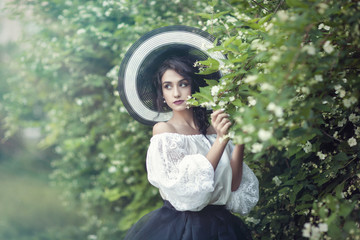Fototapeta premium A girl in a beautiful vintage dress with jasmine flowers