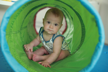 Baby sitting in the play tunnel