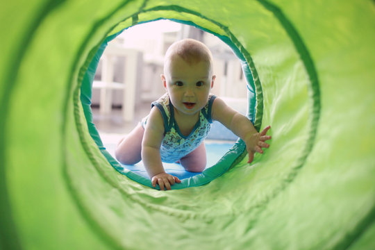 Baby crawling through the play tunnel