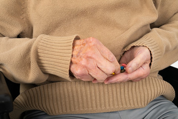 Elderly hands holding pills