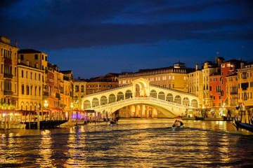 Fototapeta na wymiar Rialto bridge Ponte di Rialto over Grand Canal at night in Venice, Italy