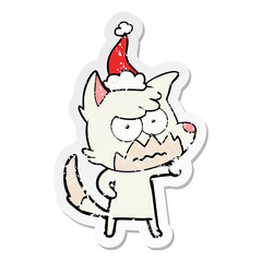 distressed sticker cartoon of a annoyed fox wearing santa hat