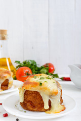 Potato balls with minced meat in deep fat, baked with mozzarella. Vertical view.