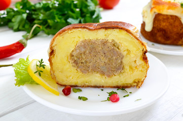 Potato balls with minced meat in deep fat, baked with mozzarella. Cut, close-up