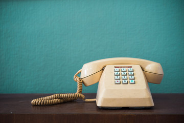 Old telephone with dust and scratches with vintage green background, retro style concept
